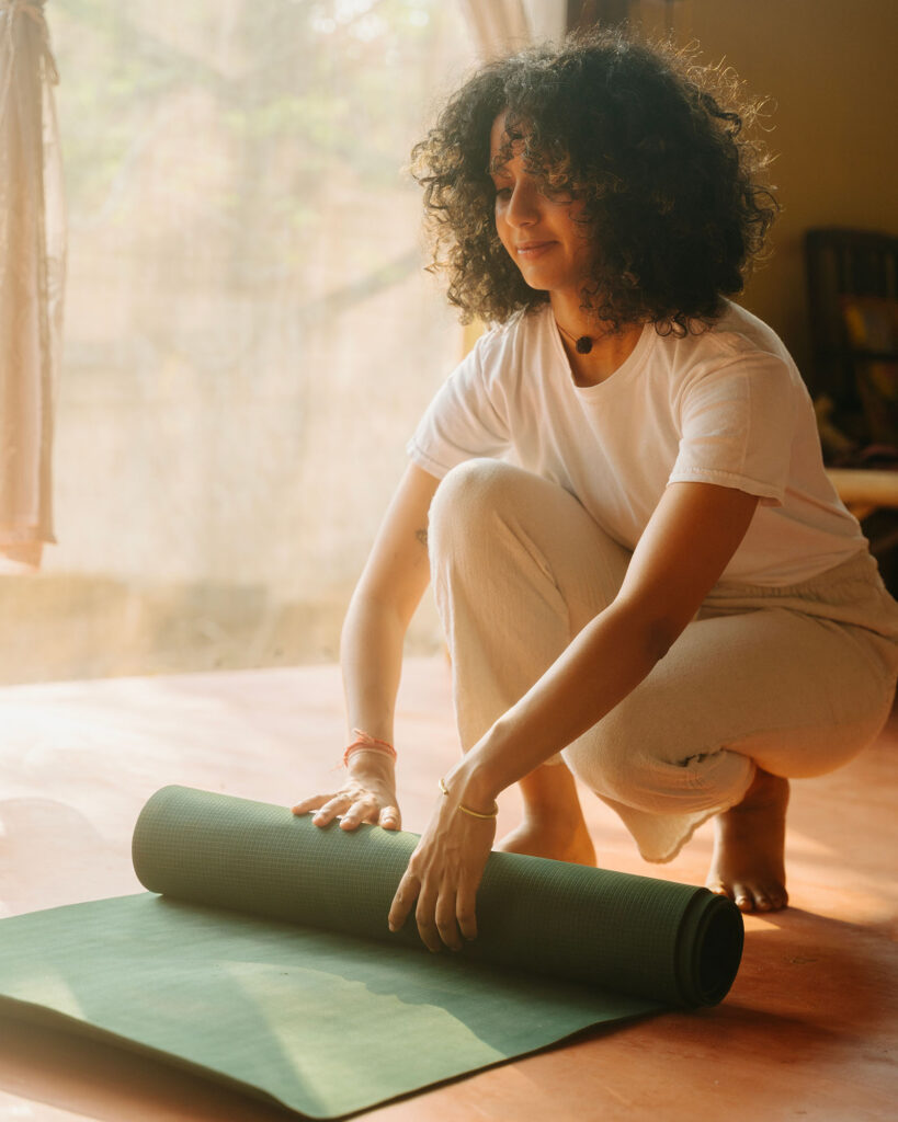 image of young woman rolling yoga mat